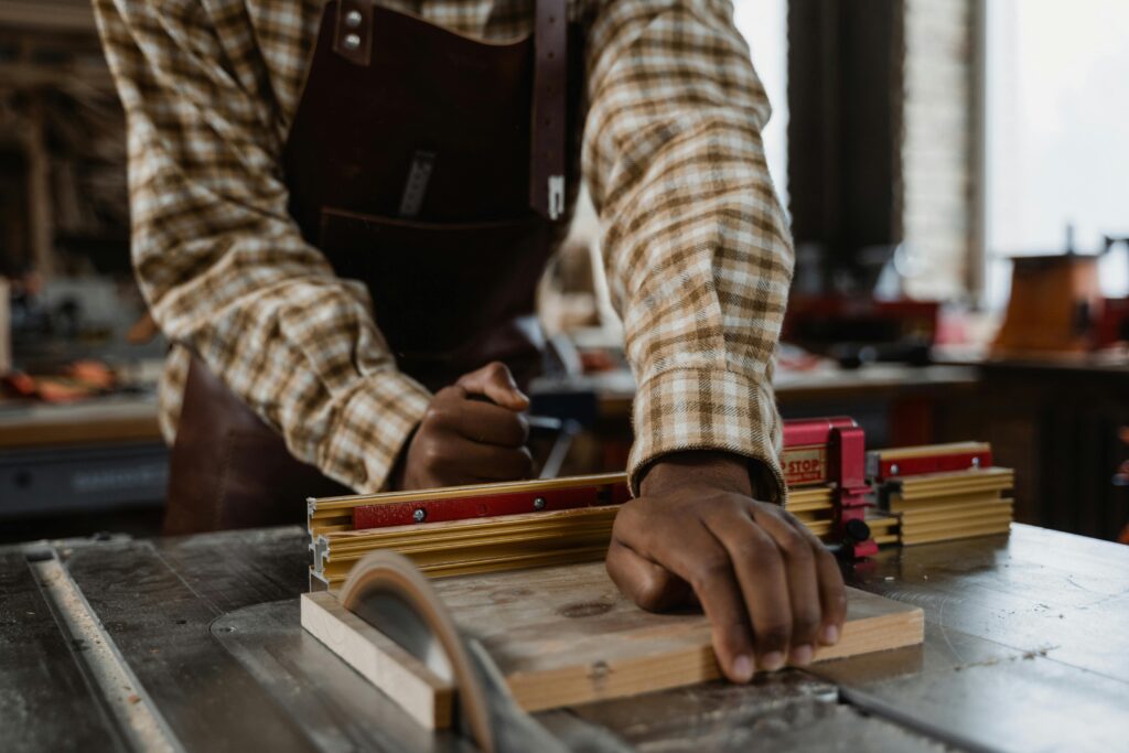 A craftsman focuses intently while working on a wooden project in a well-lit workshop.